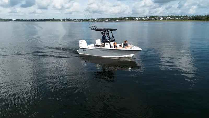 Slide: The Image of A 2027 Scout 200 Sportfish boat on calm water with two people on board. - 15