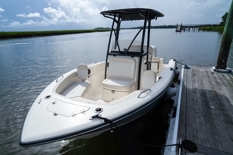Slide: The Image of Scout 200 Sportfish 2027 at dock, featuring T-top and spacious deck. - 19