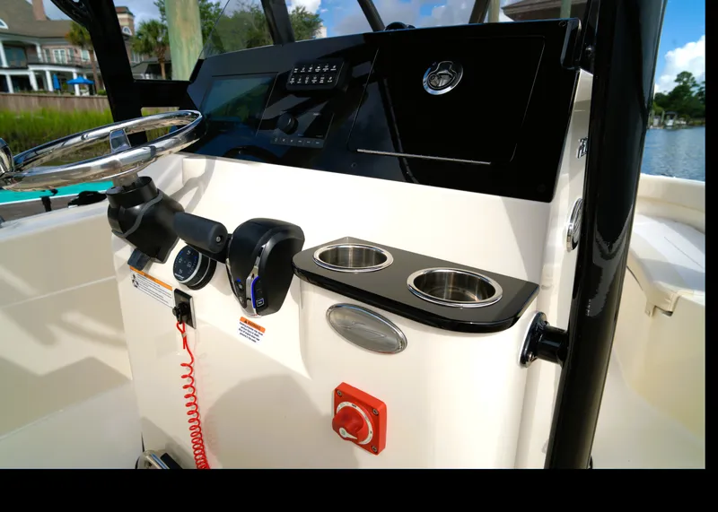 Slide: The Image of The image shows the cockpit of a Scout 200 Sportfish boat with controls and cup holders. - 31