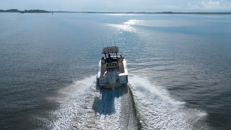 Slide: The Image of A Scout 200 Sportfish boat cruising on calm water, leaving a trail of waves behind. - 13
