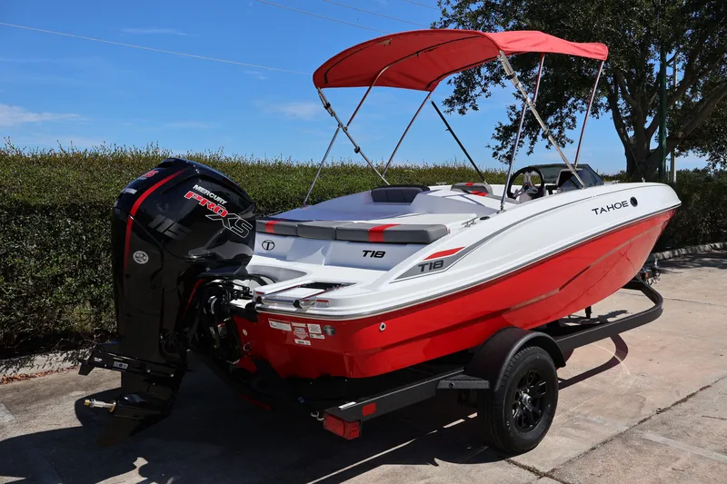 The Image of 2027 Tahoe T18 boat with red and white design, parked on a trailer. - 0