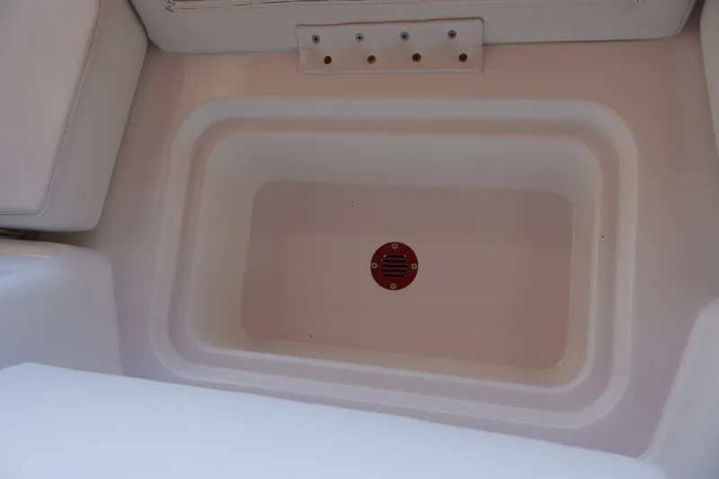 Slide: The Image of 2027 Tahoe T18 boat storage compartment with drain, featuring white interior design. - 24