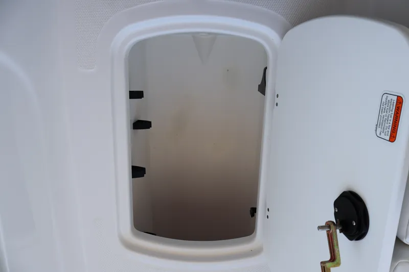 Slide: The Image of Open storage compartment in 2027 Tahoe T18 boat, featuring a white interior and secure latch. - 19