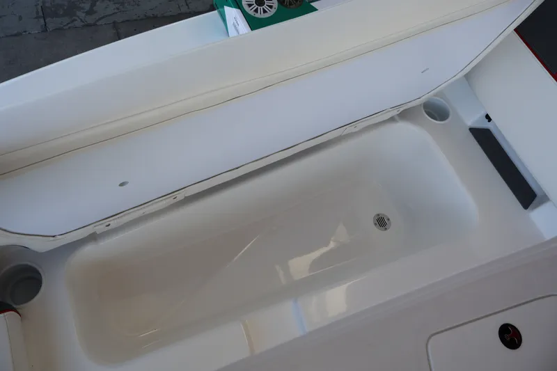 Slide: The Image of Open storage compartment in 2027 Tahoe T18 boat, featuring a drain and cup holders. - 20