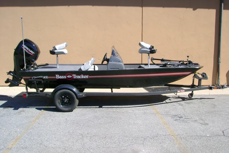 The Image of 2027 Tracker Bass Tracker Classic XL fishing boat on trailer, parked outdoors. - 0