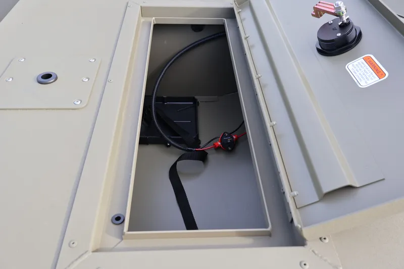 Slide: The Image of 2027 Tracker Grizzly 1648 SC boat storage compartment with wiring and warning label. - 15
