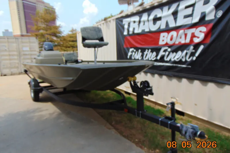 The Image of 2027 Tracker Grizzly 1754 SC boat on trailer, displayed outdoors near Tracker Boats banner. - 0