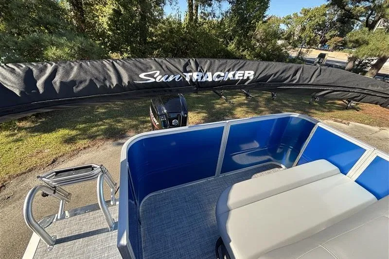 Slide: The Image of 2027 Sun Tracker Party Barge 18 DLX pontoon boat with canopy, parked outdoors. - 25