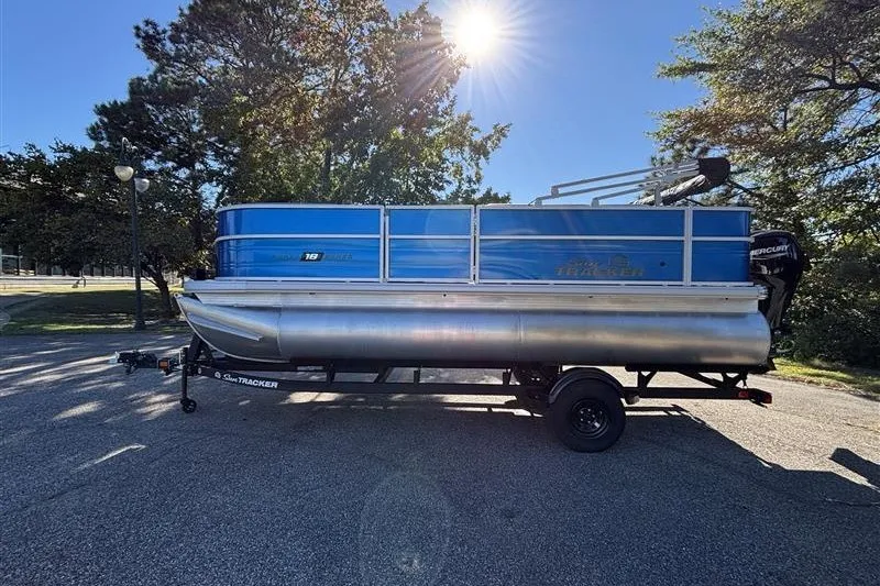 Slide: The Image of 2027 Sun Tracker Party Barge 18 DLX pontoon boat on trailer, parked outdoors. - 27