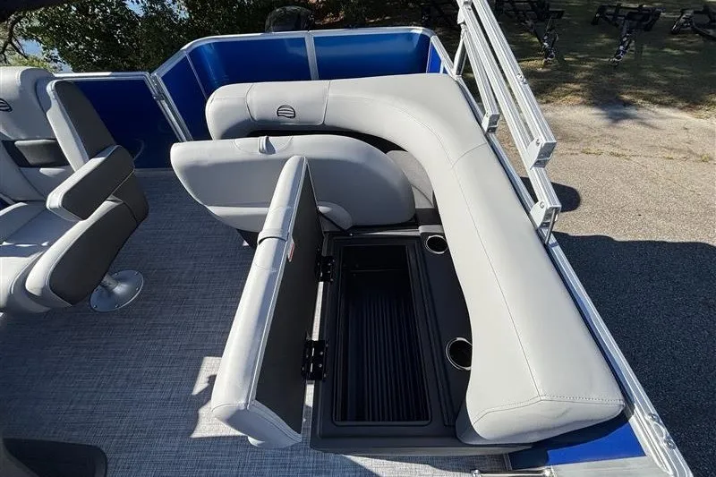 Slide: The Image of 2027 Sun Tracker Party Barge 18 DLX with open storage compartment and gray seating. - 23