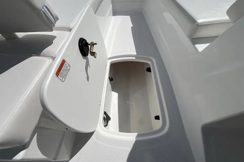 Slide: The Image of An open storage compartment on a boat with white upholstery and a black handle. - 13