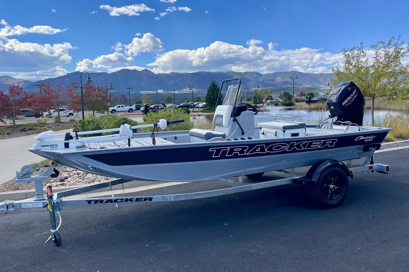 Slide: The Image of 2027 Tracker Bass Tracker Classic CC boat on trailer, scenic mountain backdrop. - 14