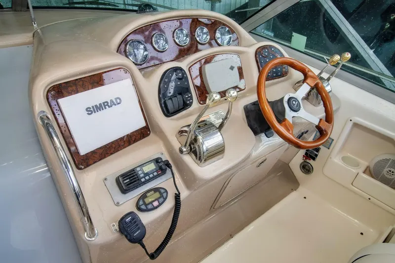 Slide: The Image of 2005 Sea Ray 340 Sundancer helm with Simrad navigation and wood-accented steering wheel. - 5