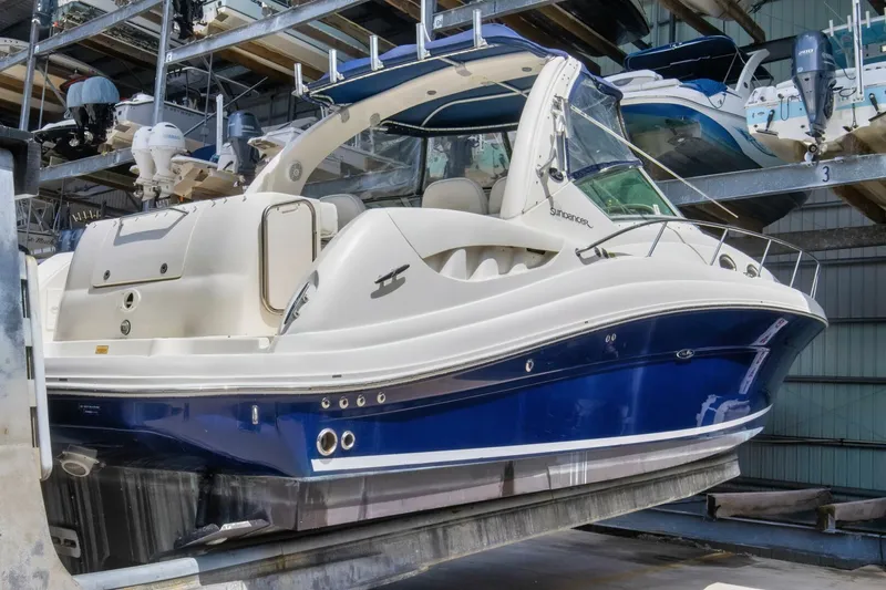 Slide: The Image of 2005 Sea Ray 340 Sundancer boat in storage, featuring sleek blue and white design. - 3