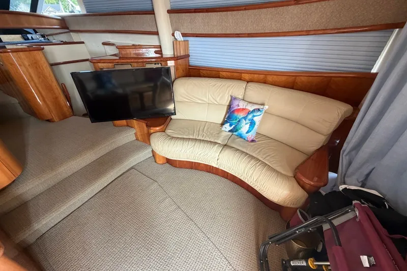 Slide: The Image of Luxurious 2004 Neptunus 56 Flybridge interior with curved sofa and flat-screen TV. - 21