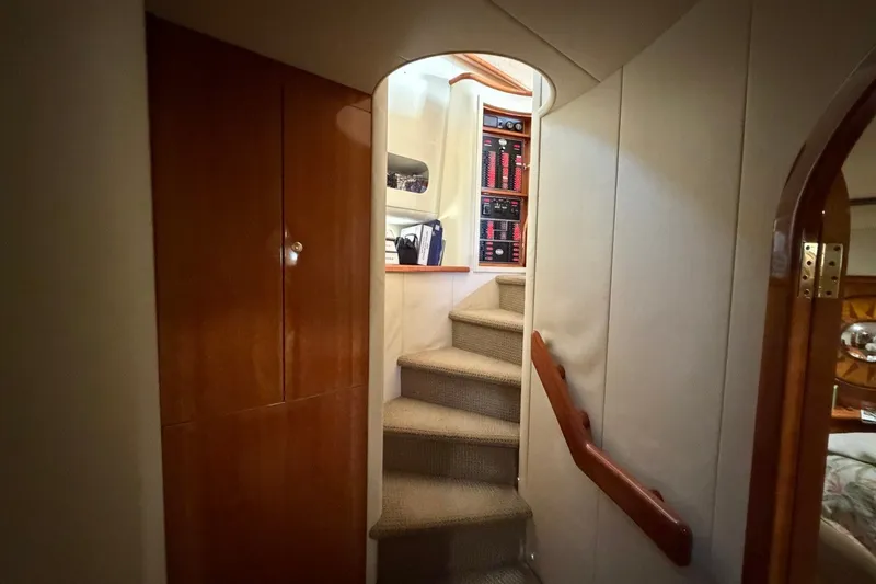 Slide: The Image of Interior staircase of 2004 Neptunus 56 Flybridge yacht, featuring wooden cabinetry and carpeted steps. - 52