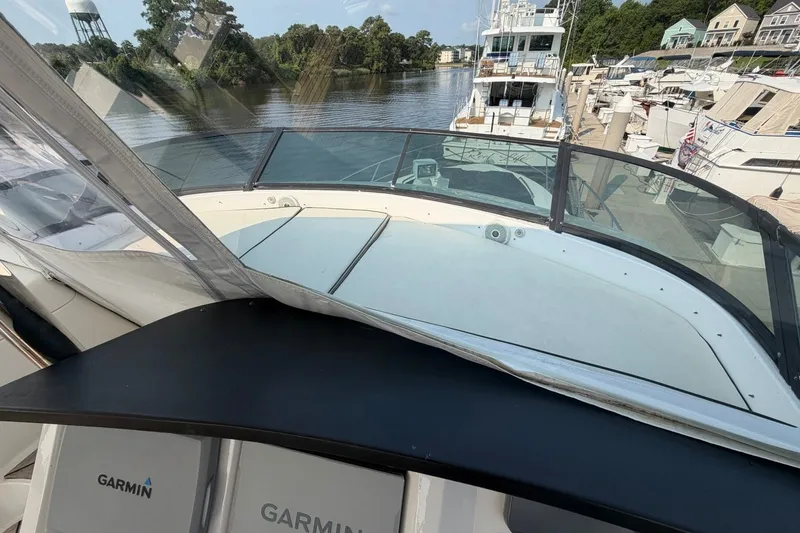 Slide: The Image of 2004 Neptunus 56 Flybridge yacht docked, featuring Garmin navigation equipment and scenic waterfront view. - 17
