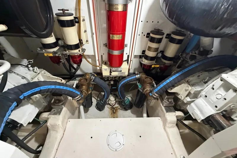 Slide: The Image of Engine room of 2004 Neptunus 56 Flybridge yacht, featuring hoses and filtration systems. - 60