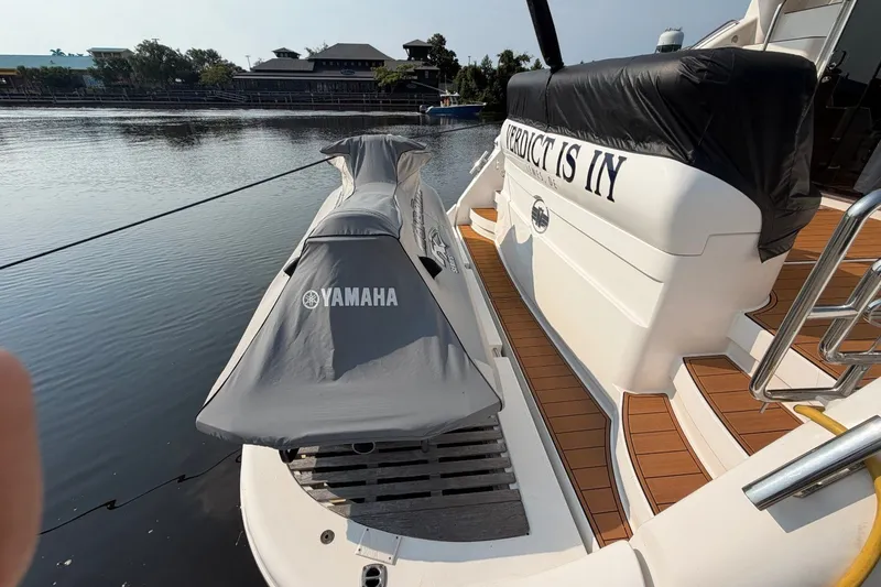 Slide: The Image of 2004 Neptunus 56 Flybridge yacht with Yamaha jet ski on deck, docked by calm waters. - 5
