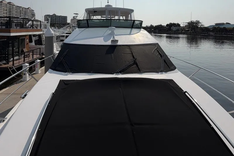 Slide: The Image of 2004 Neptunus 56 Flybridge yacht docked at marina, featuring sleek design and covered deck. - 67