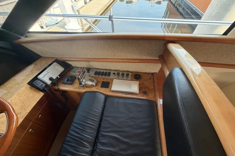 Slide: The Image of Helm station of 2004 Neptunus 56 Flybridge yacht with navigation controls and leather seating. - 30