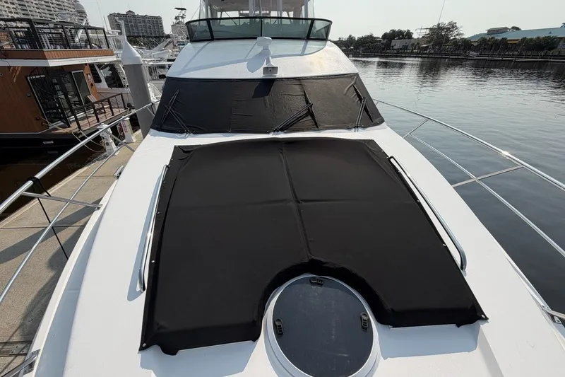 Slide: The Image of 2004 Neptunus 56 Flybridge yacht with black covers docked at marina. - 66