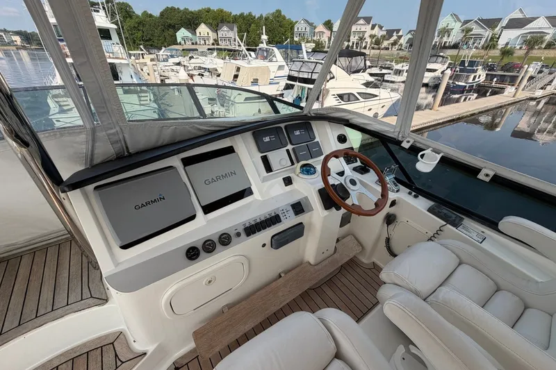 Slide: The Image of Flybridge helm of 2004 Neptunus 56, featuring Garmin navigation, overlooking marina. - 13