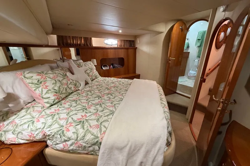 Slide: The Image of Luxurious 2004 Neptunus 56 Flybridge yacht bedroom with floral bedding and ensuite bathroom. - 40