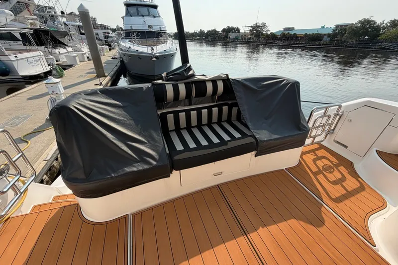 Slide: The Image of 2004 Neptunus 56 Flybridge yacht with striped seating on teak deck at marina. - 55