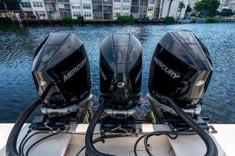 Slide: The Image of Triple Mercury outboard engines on a 2023 SeaVee 370Z boat, docked by waterfront buildings. - 53