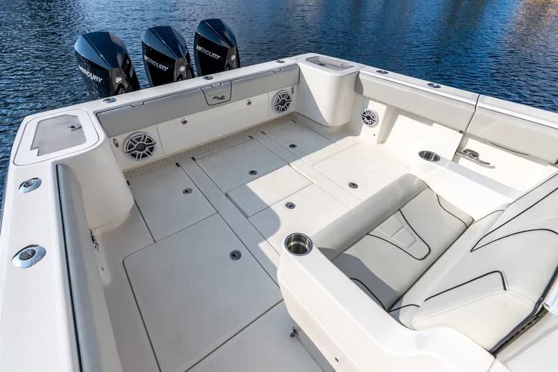 Slide: The Image of 2023 SeaVee 370Z boat deck with seating and triple Mercury engines on water. - 59