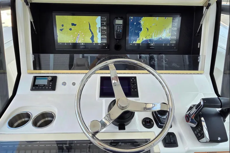 Slide: The Image of Helm of 2023 SeaVee 370Z boat with dual navigation screens and modern controls. - 6