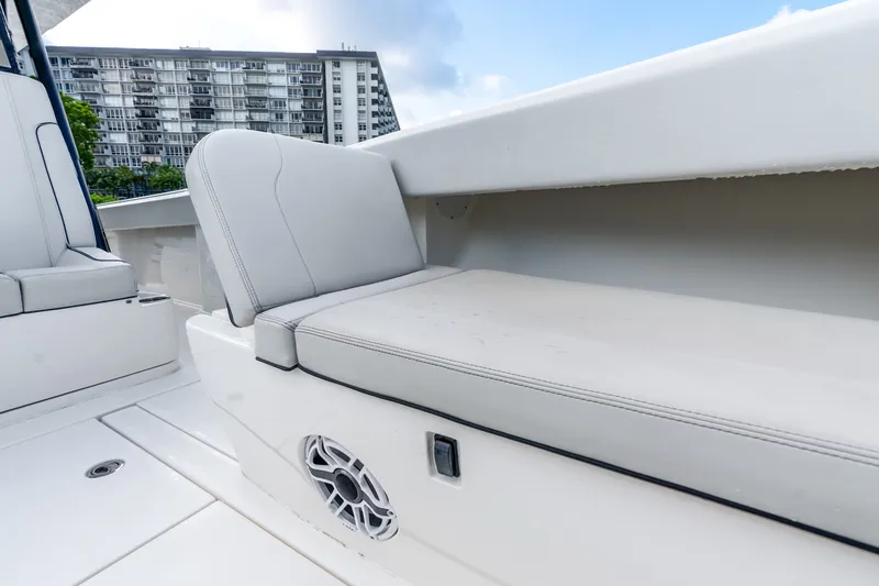 Slide: The Image of 2023 SeaVee 370Z boat interior with white seating and speaker, cityscape background. - 36