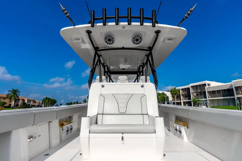 Slide: The Image of 2023 SeaVee 370Z boat with sleek design, spacious seating, and modern amenities under a clear blue sky. - 55