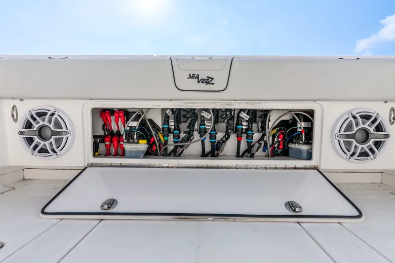 Slide: The Image of 2023 SeaVee 370Z boat electrical panel with speakers and wiring, open compartment view. - 63