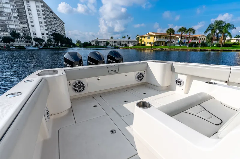 Slide: The Image of 2023 SeaVee 370Z boat with triple Mercury engines, docked near waterfront buildings. - 58