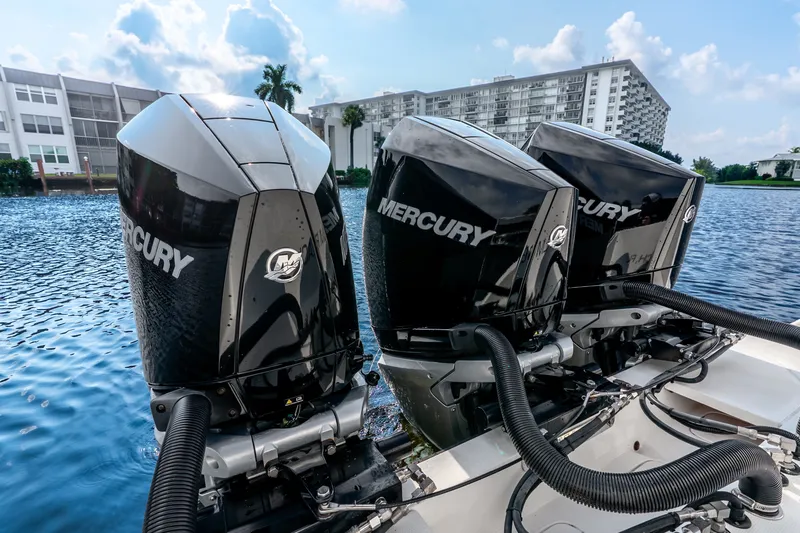 Slide: The Image of Triple Mercury outboard engines on a 2023 SeaVee 370Z boat, docked by waterfront buildings. - 54