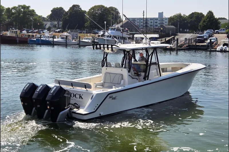Slide: The Image of 2023 SeaVee 370Z boat with triple Mercury engines in a marina setting. - 3