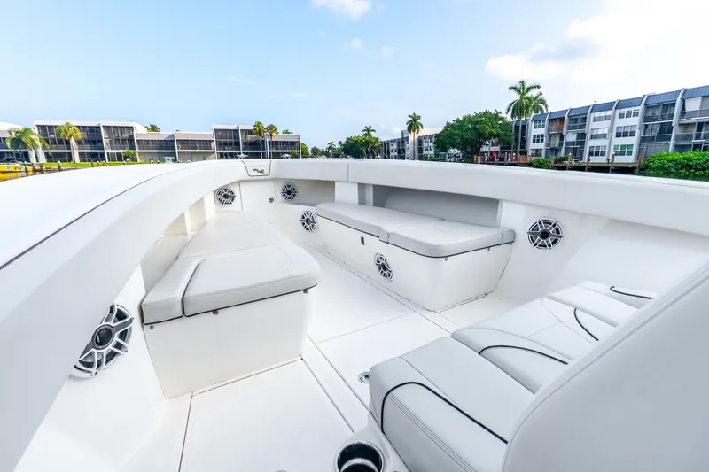 Slide: The Image of 2023 SeaVee 370Z boat interior with white seating and speakers, dockside view. - 29