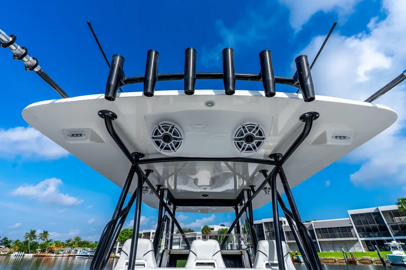 Slide: The Image of 2023 SeaVee 370Z boat with rod holders and speakers against a clear blue sky. - 47