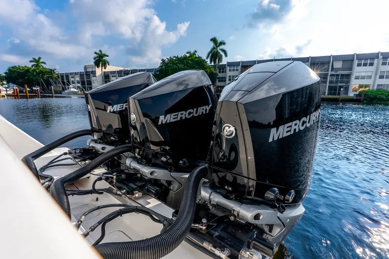 Slide: The Image of Triple Mercury outboard engines on a 2023 SeaVee 370Z boat, docked by waterfront buildings. - 51