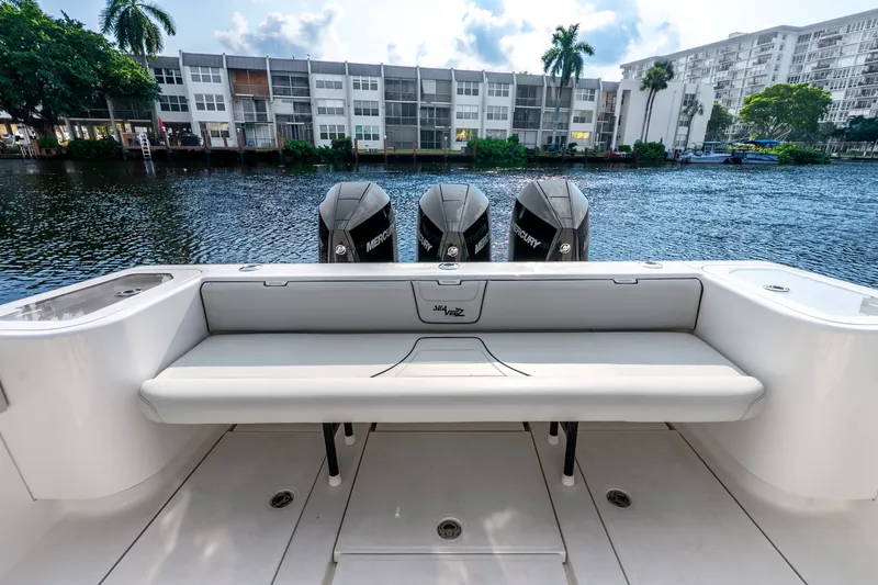 Slide: The Image of 2023 SeaVee 370Z boat with triple Mercury engines, docked by waterfront buildings. - 52