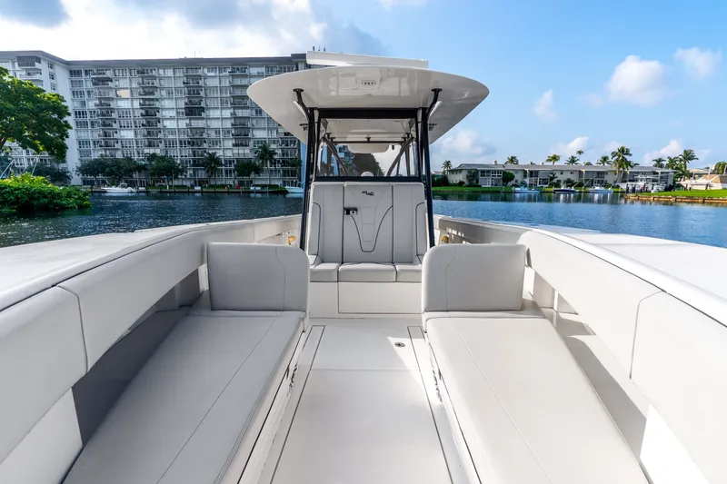 Slide: The Image of 2023 SeaVee 370Z boat interior with sleek seating, docked near waterfront buildings. - 32
