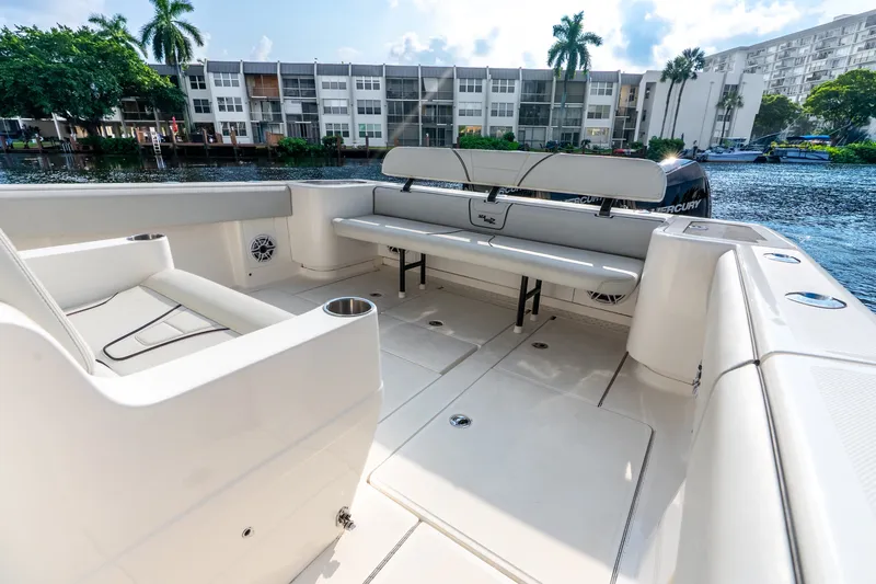 Slide: The Image of 2023 SeaVee 370Z boat interior with seating, docked near waterfront apartments. - 48
