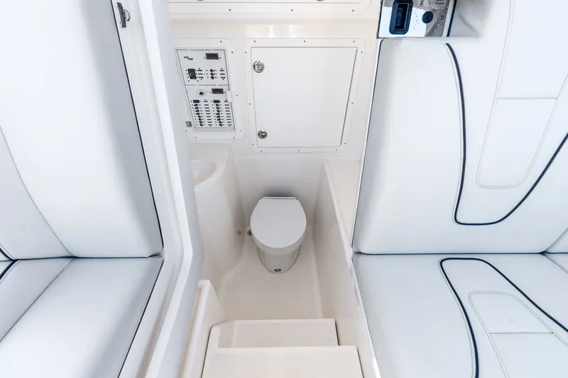 Slide: The Image of 2023 SeaVee 370Z boat interior with white seating and compact marine toilet. - 23
