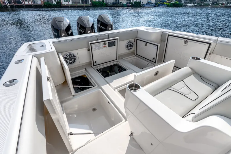 Slide: The Image of 2023 SeaVee 370Z boat interior with open storage compartments and triple Mercury engines. - 60