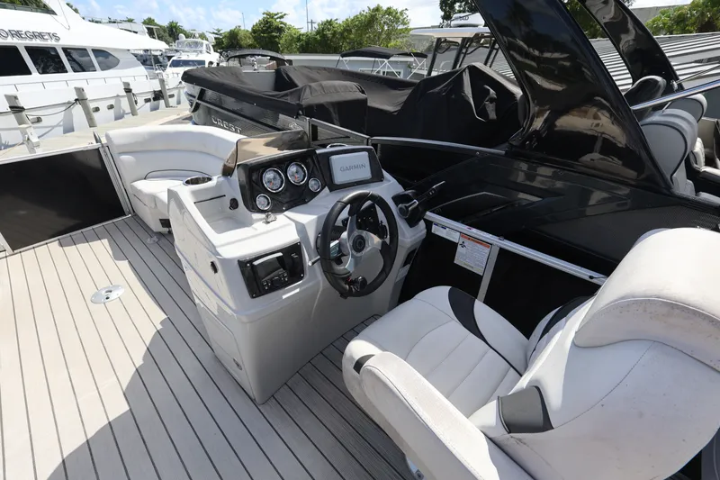 Slide: The Image of 2023 SunCatcher Select 320 RC boat interior with steering console and seating. - 14