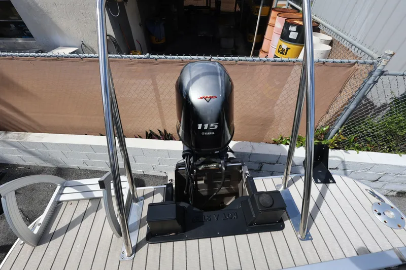 Slide: The Image of 2023 SunCatcher Select 320 RC boat with Yamaha 115 engine, docked near industrial area. - 16