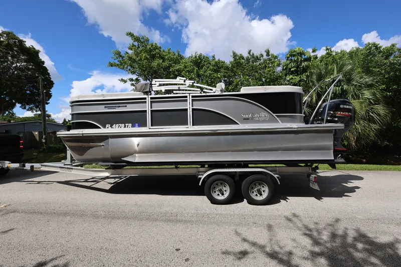 Slide: The Image of 2023 SunCatcher Select 320 RC pontoon boat on trailer, parked on a sunny street. - 3