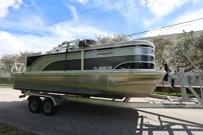 The Image of 2023 SunCatcher Select 320 RC pontoon boat on trailer, parked outdoors. - 0